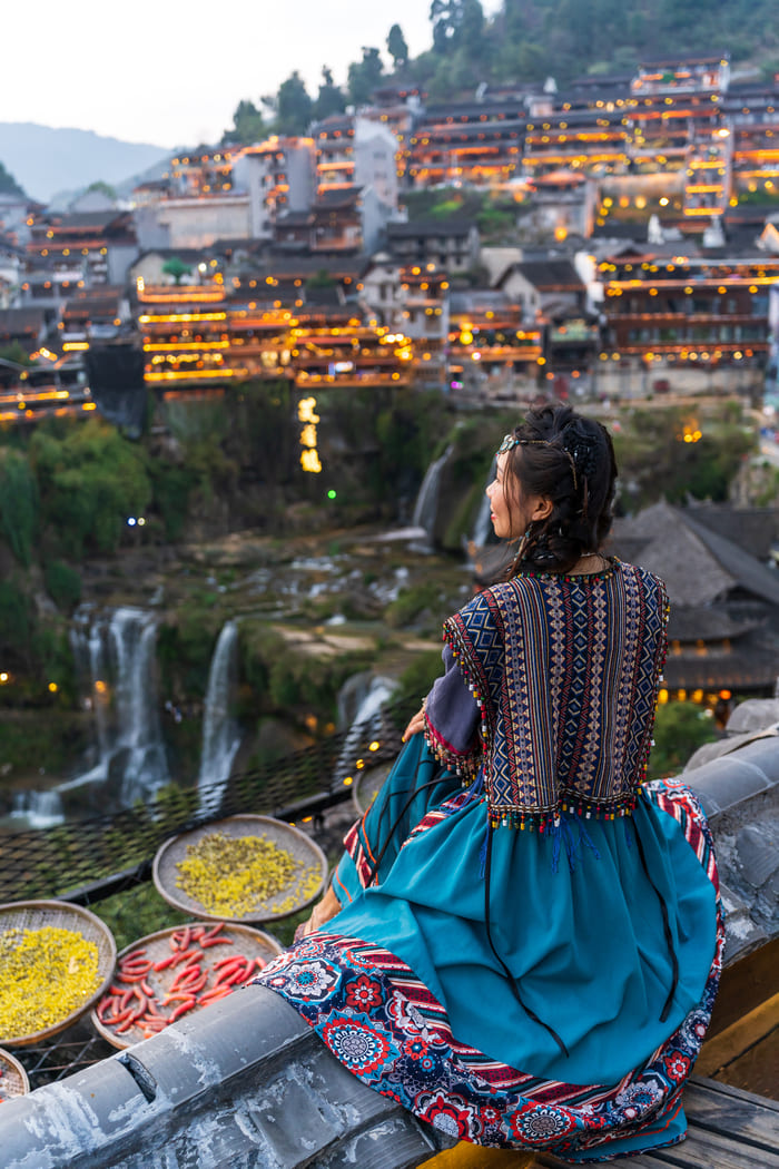 Vista panorámica de Lijiang desde un mirador, destacando la arquitectura y las luces de la ciudad